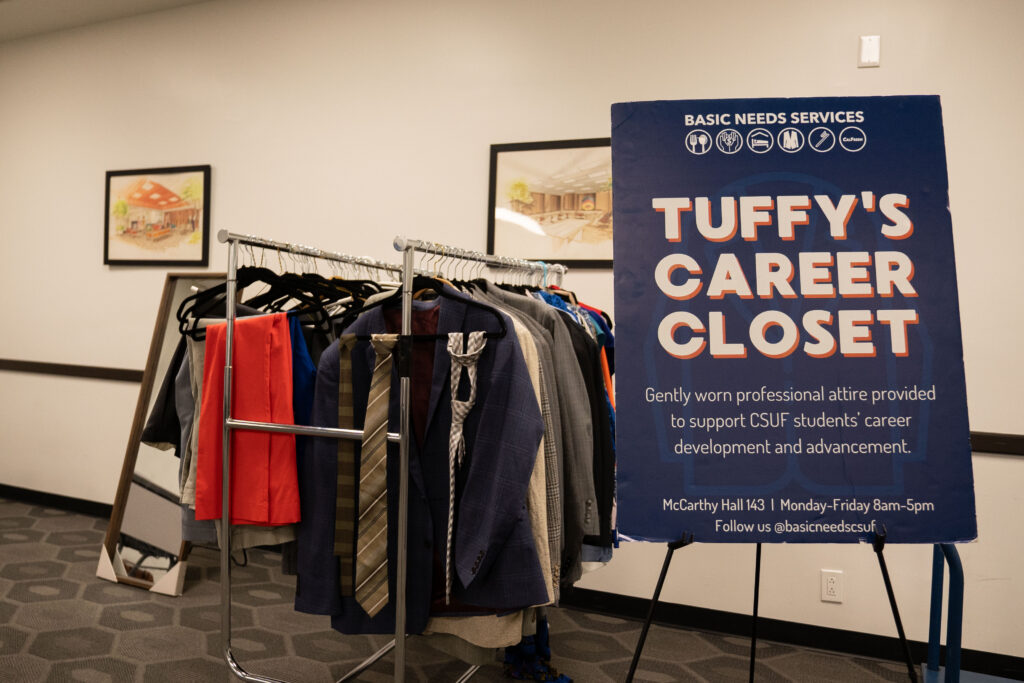 A rack of clothes and a sign next to it that reads "Tuffy's Career Closet" 