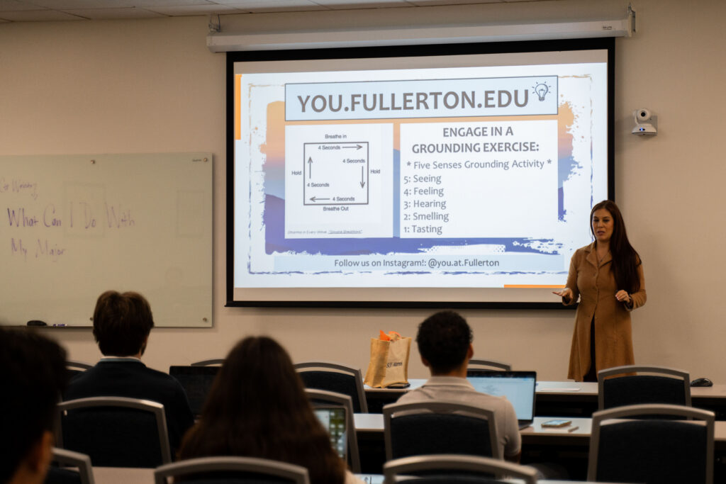 a woman gives a presentation to a group of students 
