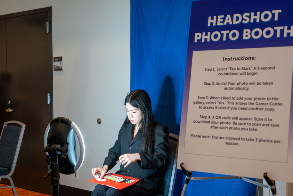 a young woman prepares to take a photo in front of a spotlight 