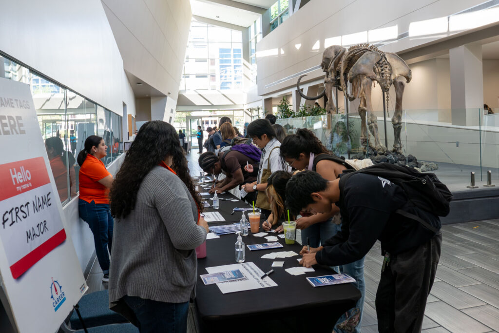 a group of students crowd a table 