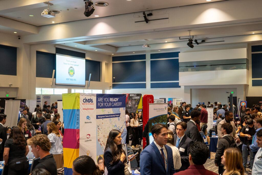 Employers talking to students within large room in the TSU Pavilions with many employer booths set up