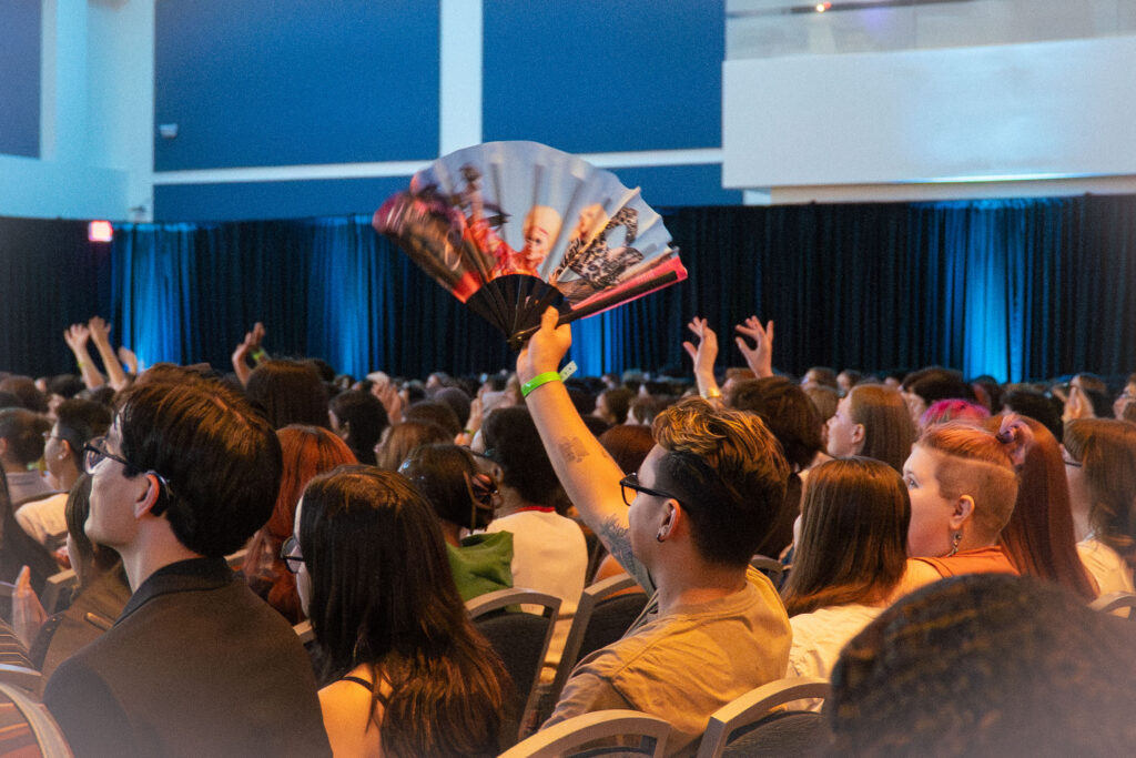 a person in an audience holding up a fan 