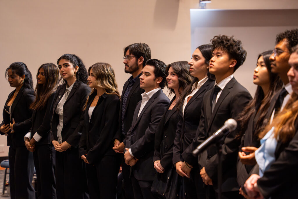 a group of college students in suits stand in a line
