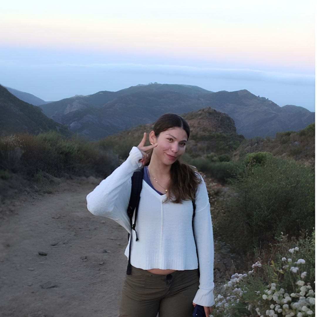 16 a girl on a hill holds up a peace sign