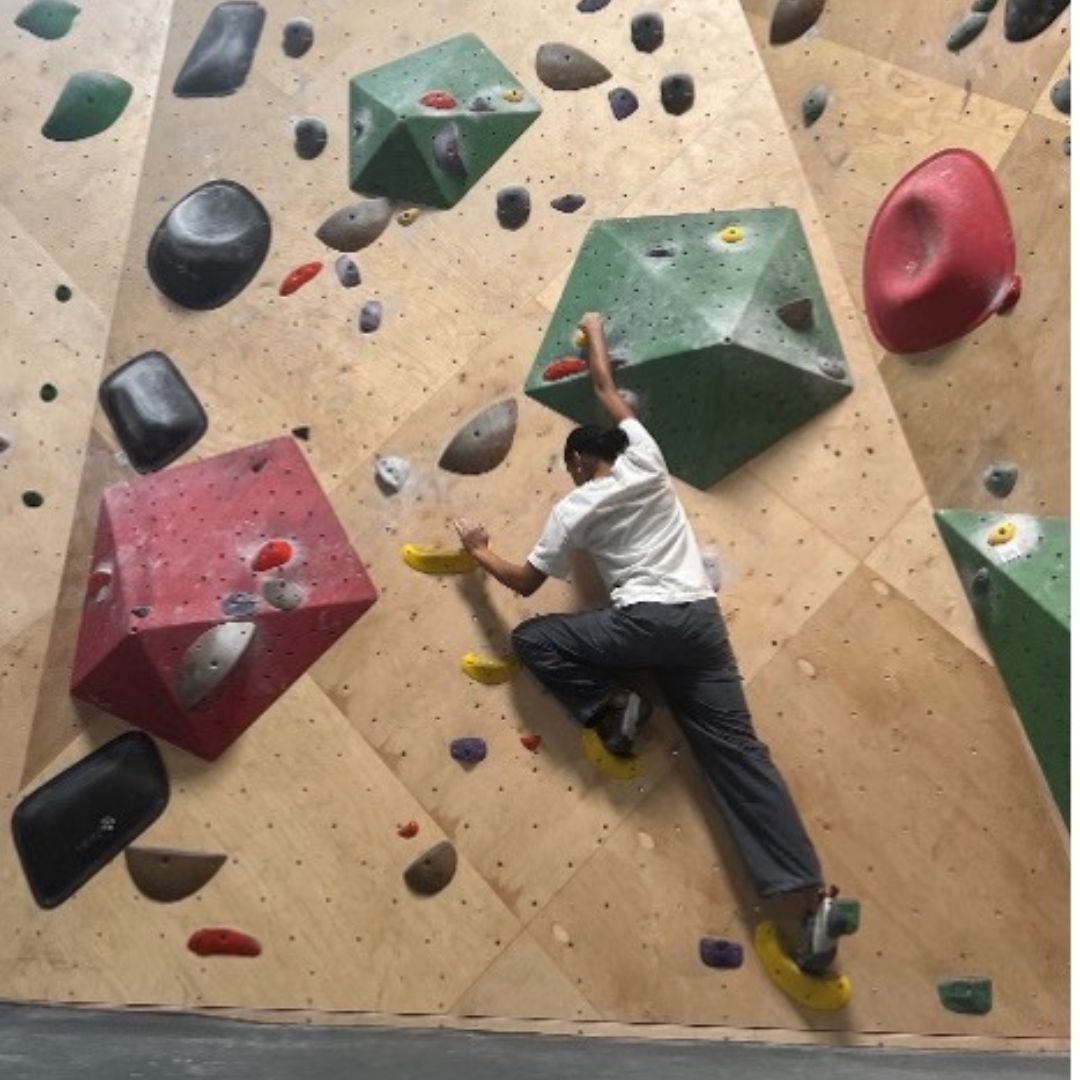 21 a woman climbs a rock wall