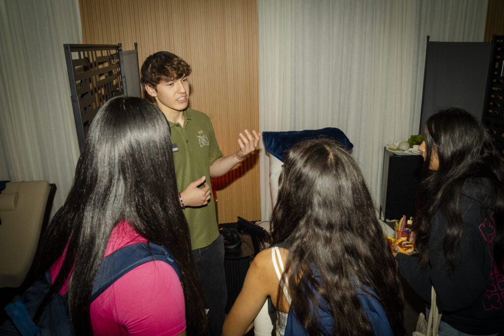 a young man explains something to students