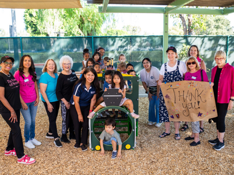 a group of women and children pose for a picture outside on a play train