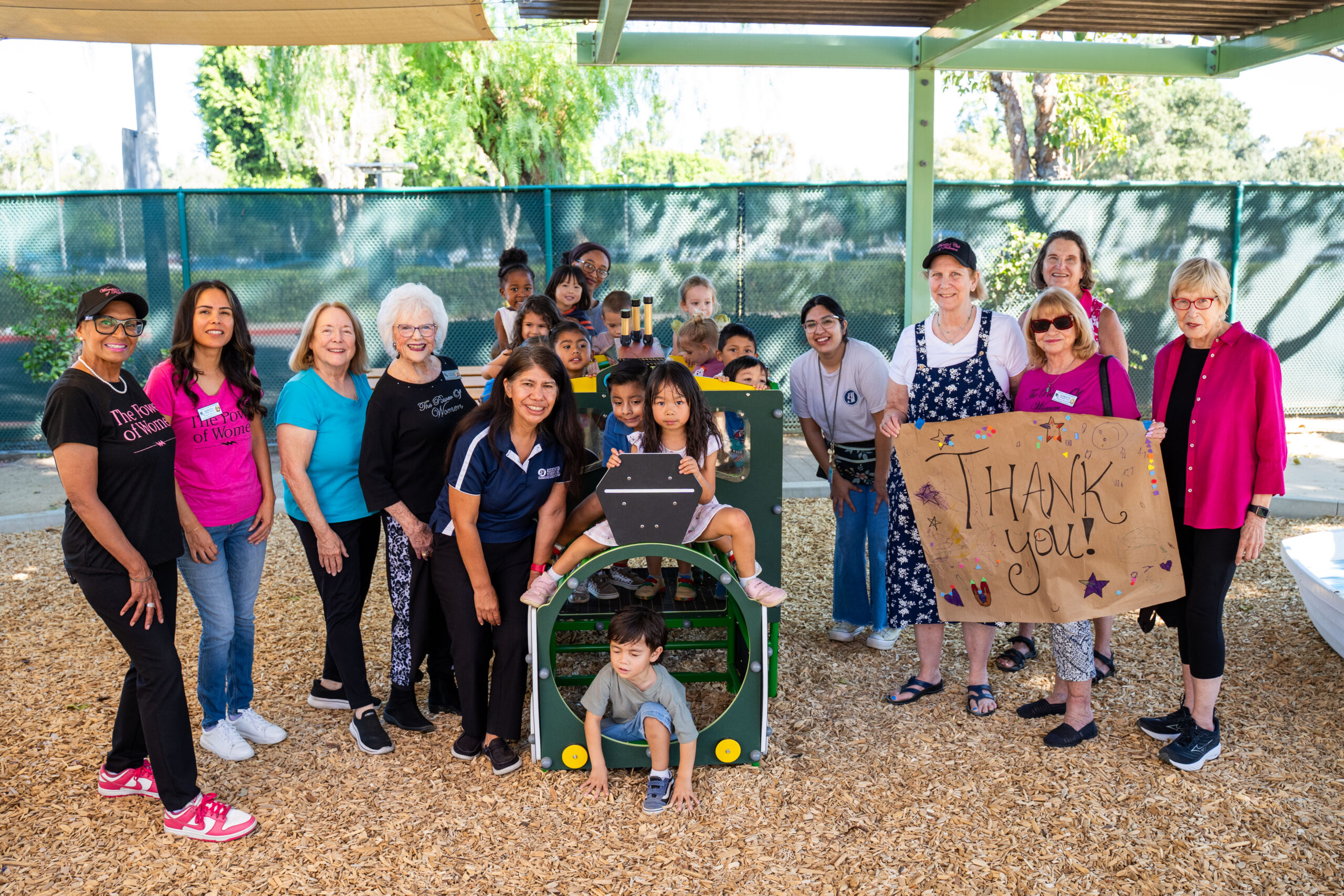 a group of women and children pose for a picture outside on a play train